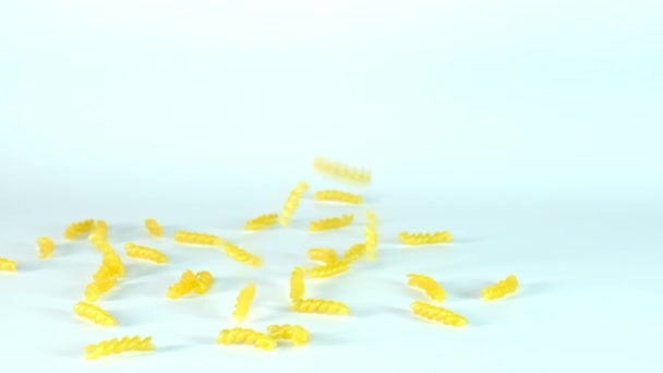 Pasta italiana fusilli cayendo sobre fondo blanco, cámara lenta, slow mo — Vídeos de Stock