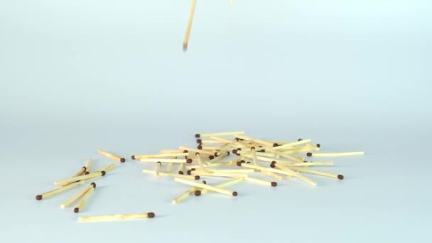 Many matchsticks, matches falling down in super slow motion against white background — Stock Video