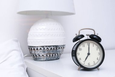 Sabahın 7 'sinde lambayla birlikte komodinin üzerinde kilitlenmiş bir çalar saat..