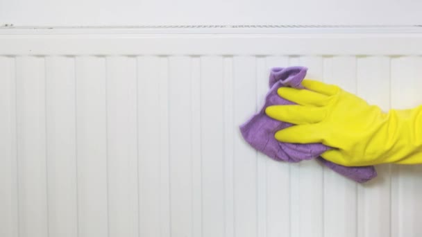 Radiator and house cleaning, hand in yellow rubber gloves wiping and washing central heating radiator with microfiber cloth — Stock Video