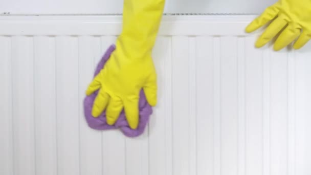 Радиатор и чистка дома, рука в желтых резиновых перчатках вытирание и мытье радиатора центрального отопления с микроволоконной тканью — стоковое видео