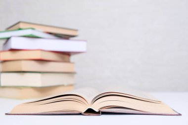 Kitap sevgisi, okuma, masanın üzerinde duran bir yığın kitap ve önünde açık kitap, boşluğu kopyalamak.