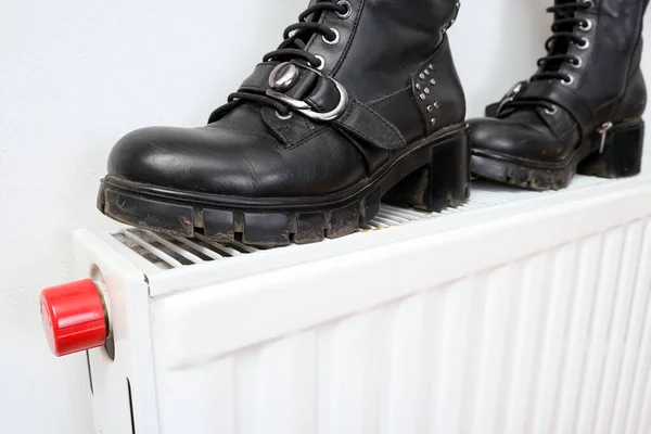 Неправильное высыхание обуви, пара грязных кожаных зимних туфель на горячем центральном отопительном радиаторе — стоковое фото
