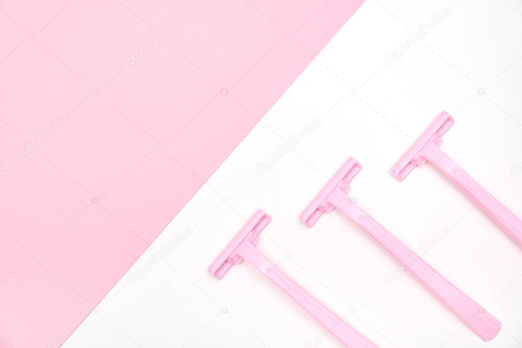 Pink disposable plastic woman razor blade for shaving, body care and unwatred hair removing on legs, armpits and face, flat lay with copy space