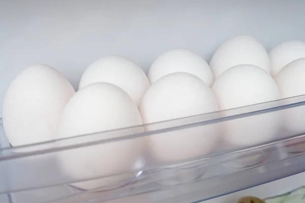 A lot of white hen chicken eggs on a shelf of a fridge, protein source for health, ingredients for fast breakfast for dieting, slimming and sports person — Stock Photo, Image