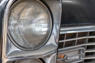 Eski bir arabanın farları hurdalığa yakın, geri dönüşüm ücreti konsepti.