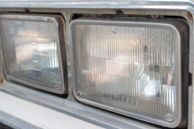 Eski bir arabanın farları hurdalığa yakın, geri dönüşüm ücreti konsepti.