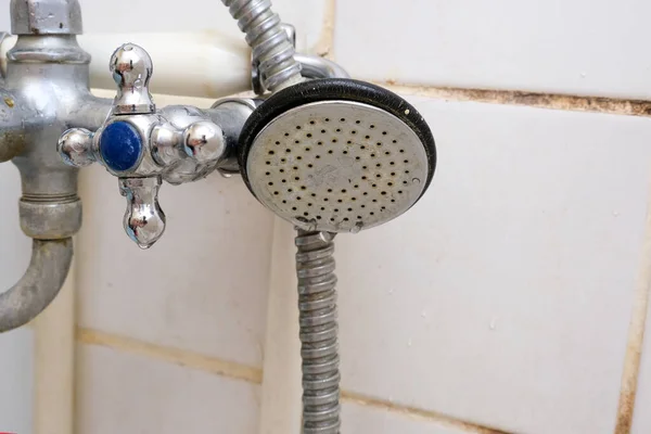 Smutsiga gamla duschhuvud med vattendroppar i närbild med kalk och förkalkad, rostig duschblandare och mögelplattor på bakgrunden, rengöring badrumskoncept — Stockfoto
