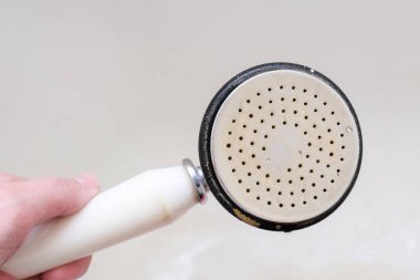 Kirli duş başlığı kireçlenmiş ve kireçlenmiş, paslı duş karıştırıcısı ve arka planda küflü fayanslar, temizlik banyosu konsepti