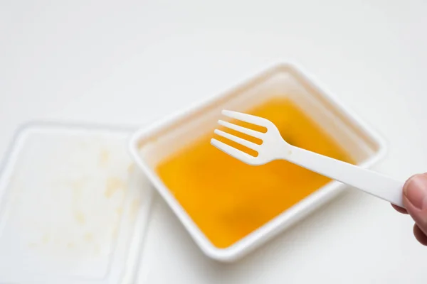 Jíst instantní vaječné nudle z jednorázové nádoby s plastovým folkem zblízka, rychlé jídlo koncepce — Stock fotografie