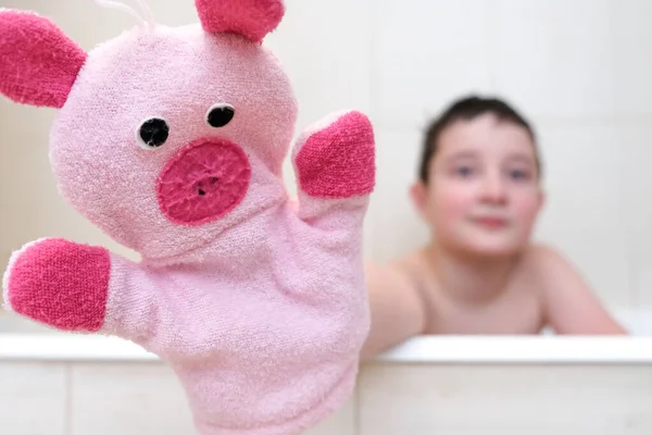 Egy fiú a fürdőszobában mutatja vicces malac kéz bábu játék mosás ruha közelről, boldog mosás és zuhany koncepció — Stock Fotó