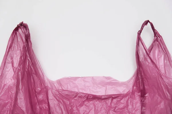 Punhos de um saco de plástico vermelho no fundo branco — Fotografia de Stock