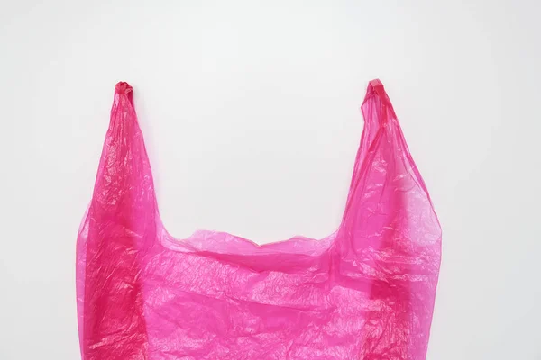 Asas de una bolsa de plástico rosa sobre fondo blanco — Foto de Stock