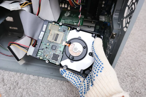 Москва, Россия - 10 сентября 2020 г.: Инженер меняет жесткий диск офисного компьютера, ремонтирует и фиксирует сломанный жесткий диск для восстановления данных — стоковое фото