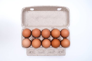 Geri dönüştürülmüş kahverengi yumurtalar, beyaz masadaki basılmış kutu kutusunda.