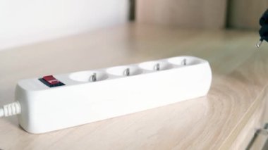 Elektrik prizine takılan bir el yakın çekim, şarj cihazları konsepti