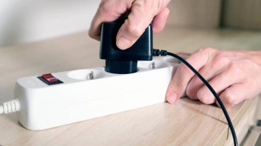 Elektrik prizine takılan bir el yakın çekim, şarj cihazları konsepti
