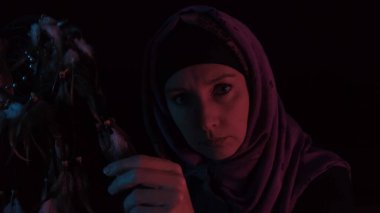 Kızgın bir cadı büyücülük yapıyor ve gecenin karanlığında tüylerle büyü yapıyor.