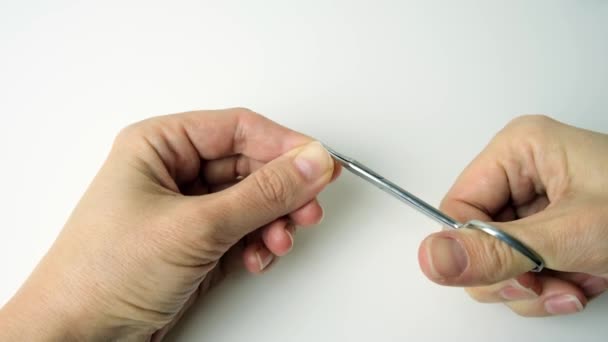Ruka ženy, jak si sama doma stříhá nehty nůžkami a dělá manikúru — Stock video