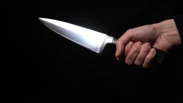 En hand av en mördare eller rånare som håller en stor kniv och visar en vass kniv på natten på nära håll — Stockvideo