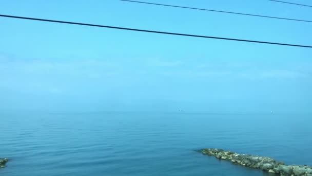 Havsutsikt, landskap med små fartyg och båtar långt bort från ett tågfönster — Stockvideo