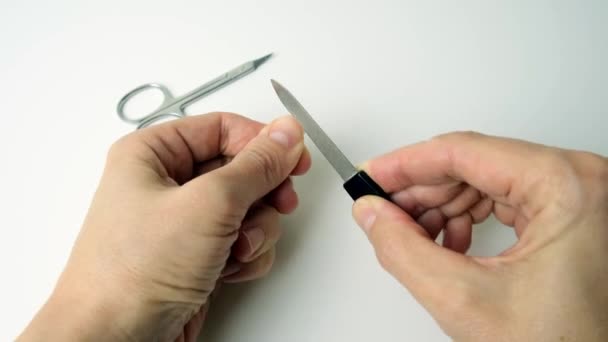 Mano de una mujer limando uñas después de cortar con tijeras, haciendo manicura sola en casa — Vídeos de Stock