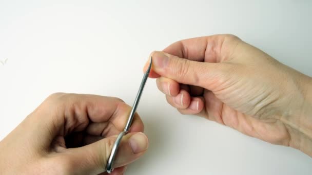 Mão de uma mulher cortando pregos com tesoura e fazendo manicure sozinha em casa — Vídeo de Stock