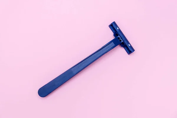Πλαστική λεπίδα ξυραφιού μίας χρήσης για καθημερινή πρωινή ρουτίνα και ξύρισμα, αφαίρεση ανεπιθύμητων τριχών σε πρόσωπο, πόδια και μασχάλες, περιποίηση σε ροζ φόντο — Φωτογραφία Αρχείου