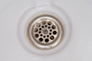 Bir lavabo drenaj delik kireç veya kireç ve pas üzerine, kirli paslı banyo küveti.