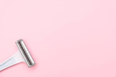 Pembe arka planda tek kullanımlık gri plastik jilet ve fotokopi alanı