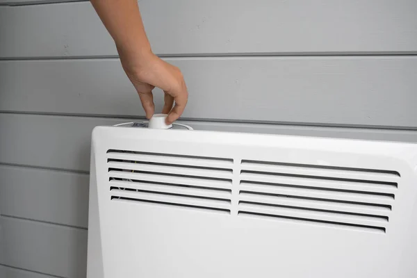 Regulación manual, ajuste de temperatura en el convector eléctrico, termoestado del calentador en la habitación en invierno, control de temperatura, calefacción doméstica y concepto de ahorro de energía — Foto de Stock