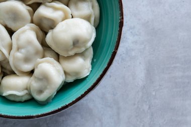 Masada yeşil tabakta lezzetli etli börekler, Rus pelmeni, kopyalama alanı.