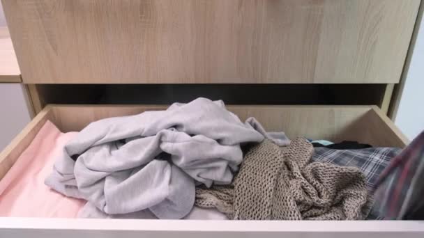 Las manos de mujer ponen la ropa en un cajón en un lío, desorden en la casa y la ropa, decluttering necesario — Vídeo de stock