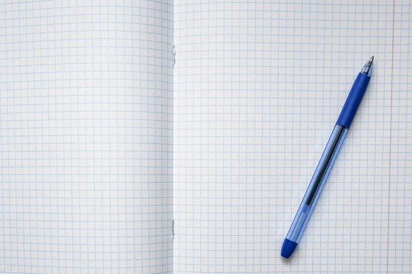 一支蓝色的圆珠笔躺在空白的校本本上 上面有一张空白的校本本 — 图库照片