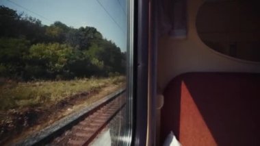 Turist treni gezisi. Hızlı bir trenin penceresinden yaz manzarası. Hızlı giden tren. Yeşil tarlalardan geçen demiryolu. Seyahat tutkusu. Eve dönüş yolu.