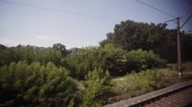 Turist treni gezisi. Hızlı bir trenin penceresinden yaz manzarası. Hızlı giden tren. Yeşil tarlalardan geçen demiryolu. Seyahat tutkusu. Eve dönüş yolu.