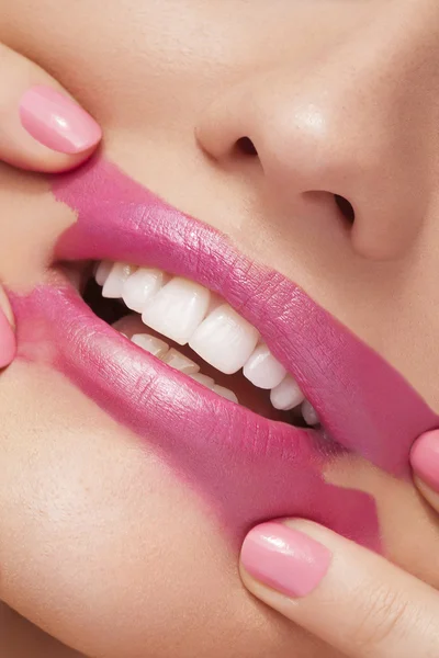 Spreading pink lipstick on face — Stock Photo, Image