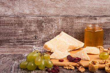 Peynir, üzüm, fındık ve bal vintage ahşap zemin üzerine