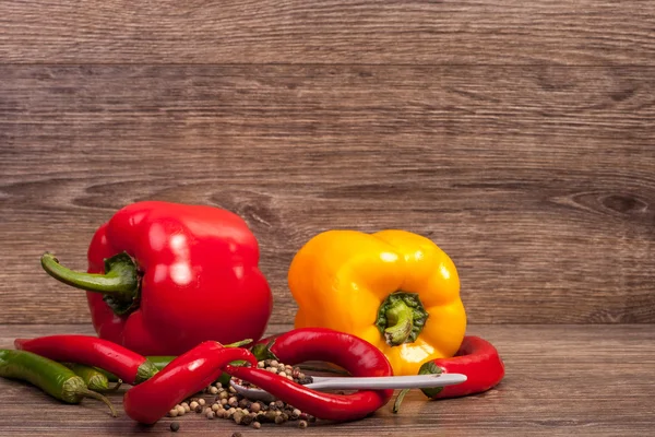 Sweet pepper and chili on wooden background — Stock Photo, Image