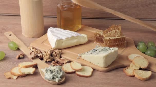 Différents types de fromage, miel et raisin sur fond de bois — Video