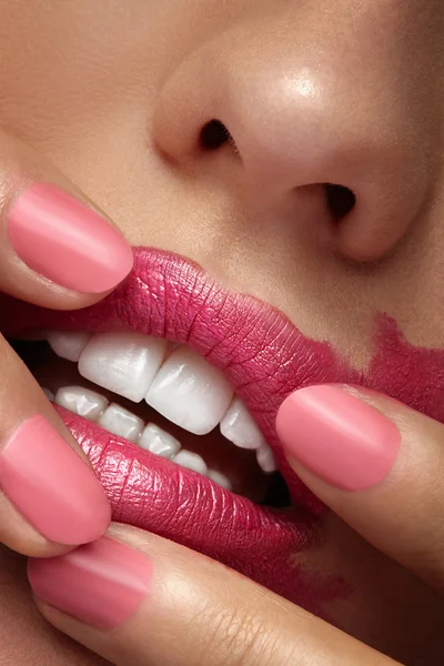 Les doigts écartant le rouge à lèvres rose sur la bouche — Photo