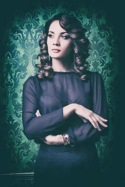 Elegant woman on vintage wall with green pattern — Stock Photo, Image