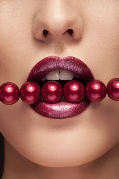 Woman with red pearls in mouts sensual posing — Stock Photo, Image