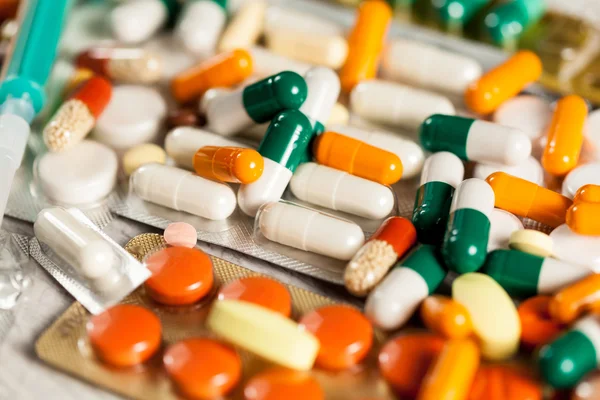 Muitas drogas e pílulas deitadas na mesa — Fotografia de Stock
