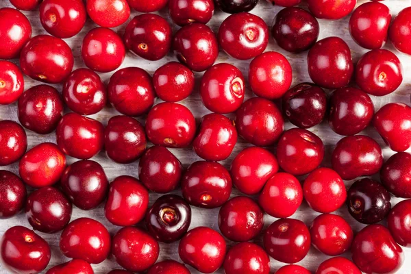 Ramo de cerezas sobre mesa de madera — Foto de Stock