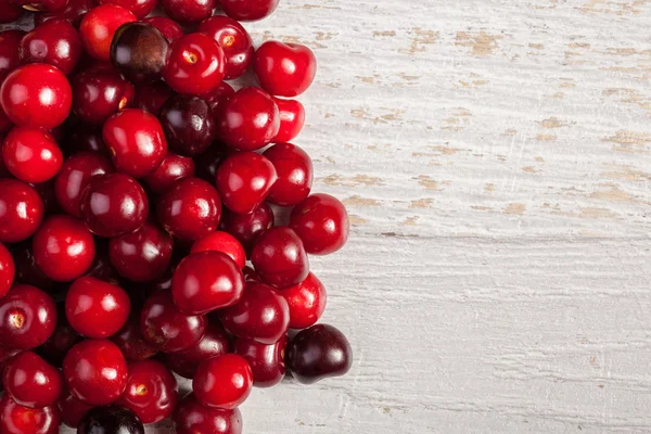 Cerezas sobre mesa de madera blanca — Foto de Stock