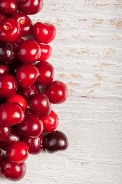 Cerezas frescas sobre mesa de madera — Foto de Stock