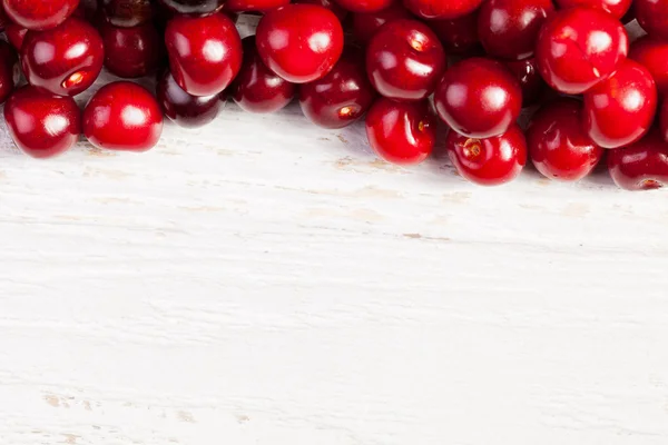 Cerezas de aspecto fresco sobre fondo de madera — Foto de Stock