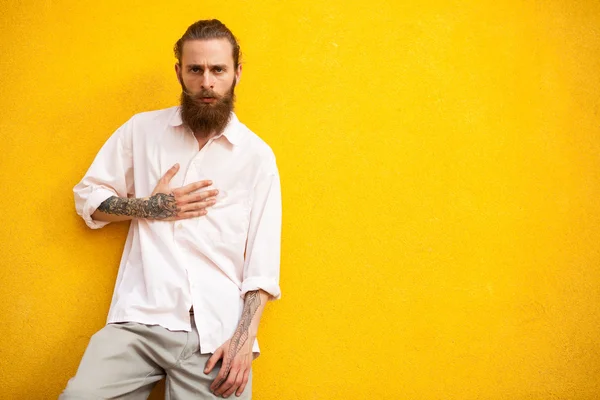 Longo hipster barbudo na parede amarela — Fotografia de Stock