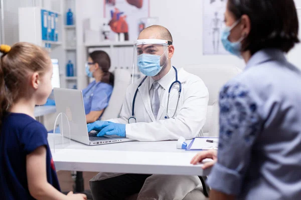 Medico in maschera e visiera consulenza bambino — Foto Stock